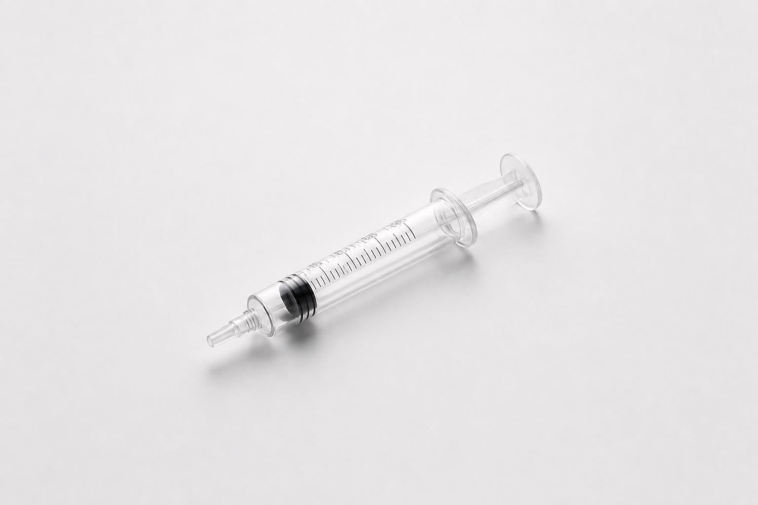 Single clear syringe on a clean white studio background